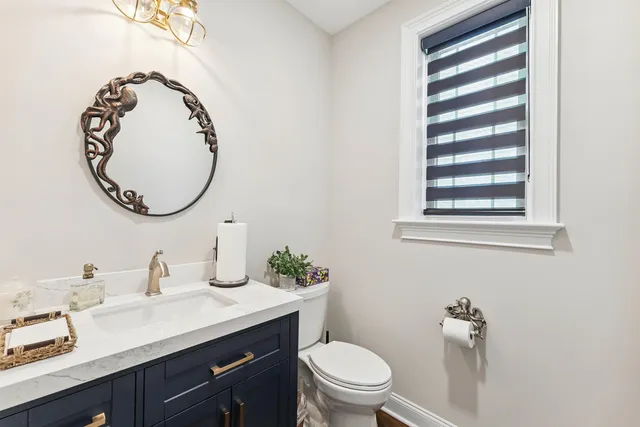 a bathroom with a toilet sink vanity and mirror