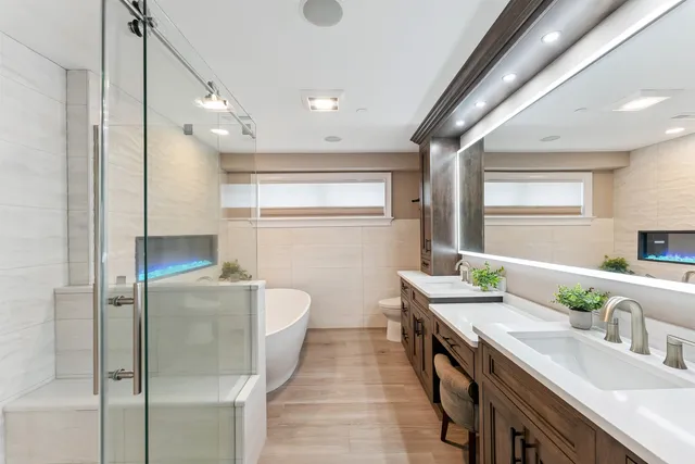 a bathroom with a double vanity sink a mirror and a shower