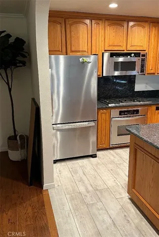 a kitchen with granite countertop a refrigerator stove and sink