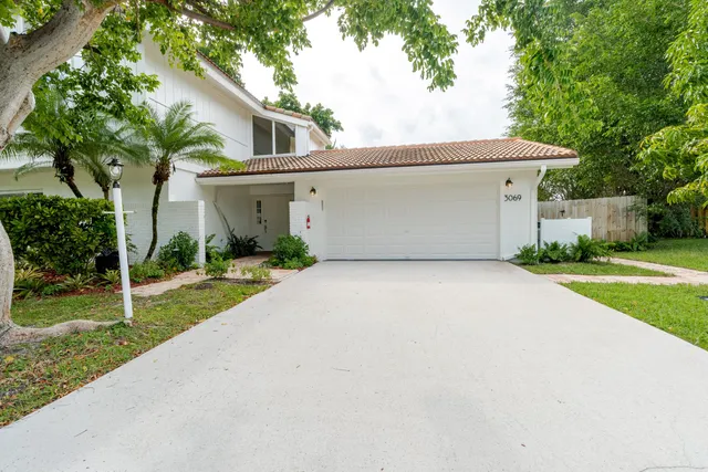 a backyard of a house with potted plants and large tree