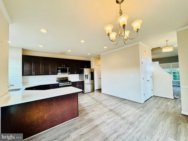 a kitchen with stainless steel appliances a stove refrigerator and wooden floor