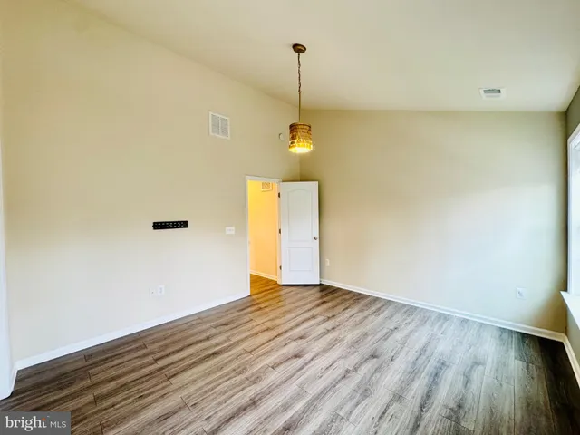 a view of a room with wooden floor and white walls