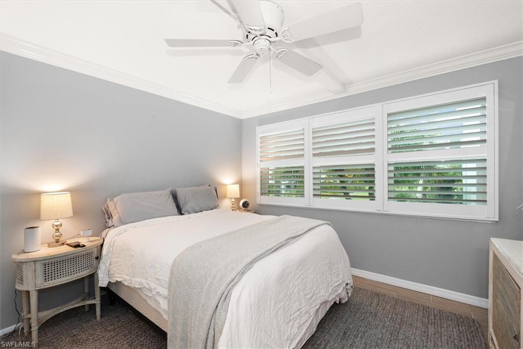 291A 8th Avenue South, Unit 291A Naples, FL 34102 - Photo 16 of 25 Bedroom with crown molding, ceiling fan and plantation shutters