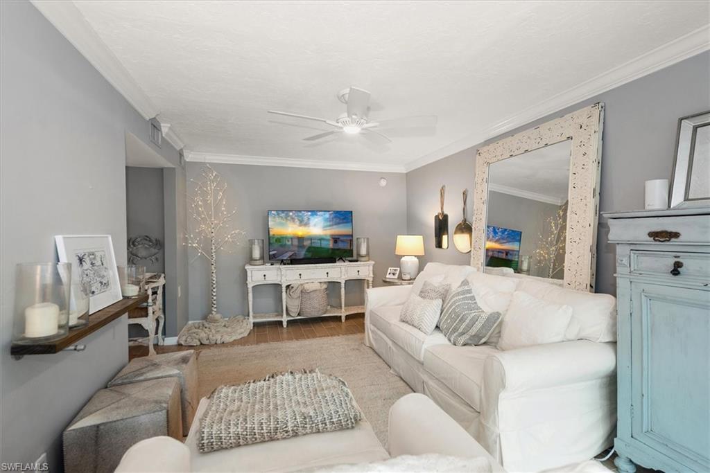 291A 8th Avenue South, Unit 291A Naples, FL 34102 - Photo 7 of 25 Living room featuring ornamental molding, wood finished floors, and ceiling fan