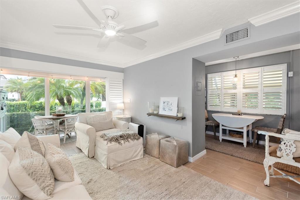 291A 8th Avenue South, Unit 291A Naples, FL 34102 - Photo 9 of 25 Living area with crown molding, wood finished floors, plenty of natural light, and ceiling fan