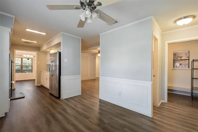 a view of a hallway with wooden floor and a kitchen