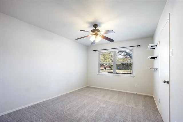 an empty room with fan and windows