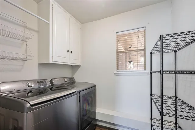 a view of a backyard with couches under an umbrella