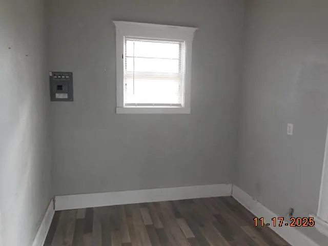 a view of a room with wooden floor and small window