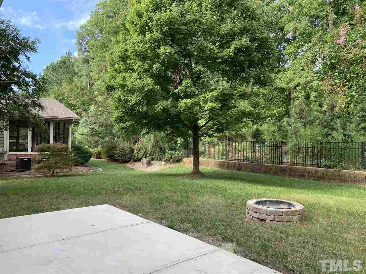 409 Amiable Loop Cary, NC 27519 - Photo 2 of 3 a backyard of a house with a garden and barbeque oven
