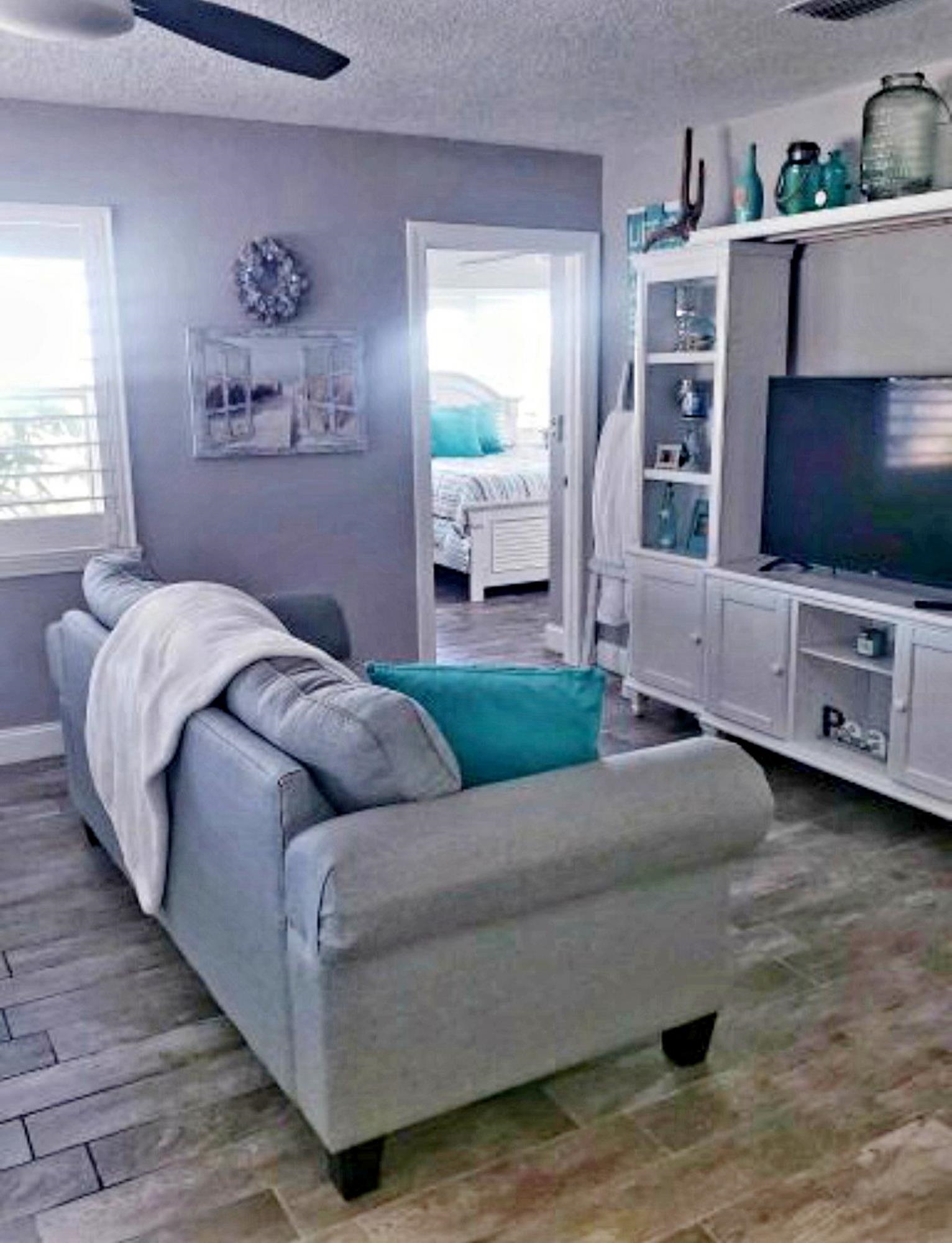 7 E Street, Unit A St. Augustine, FL 32080 - Photo 7 of 12 Living room with a textured ceiling, wood finished floors, and a ceiling fan