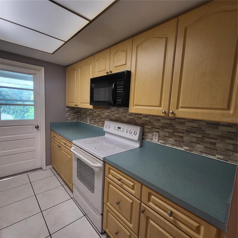 911 Washington Avenue Southwest, Unit 306 Largo, FL 33770 - Photo 6 of 14 a kitchen with stainless steel appliances granite countertop a sink and a stove top oven