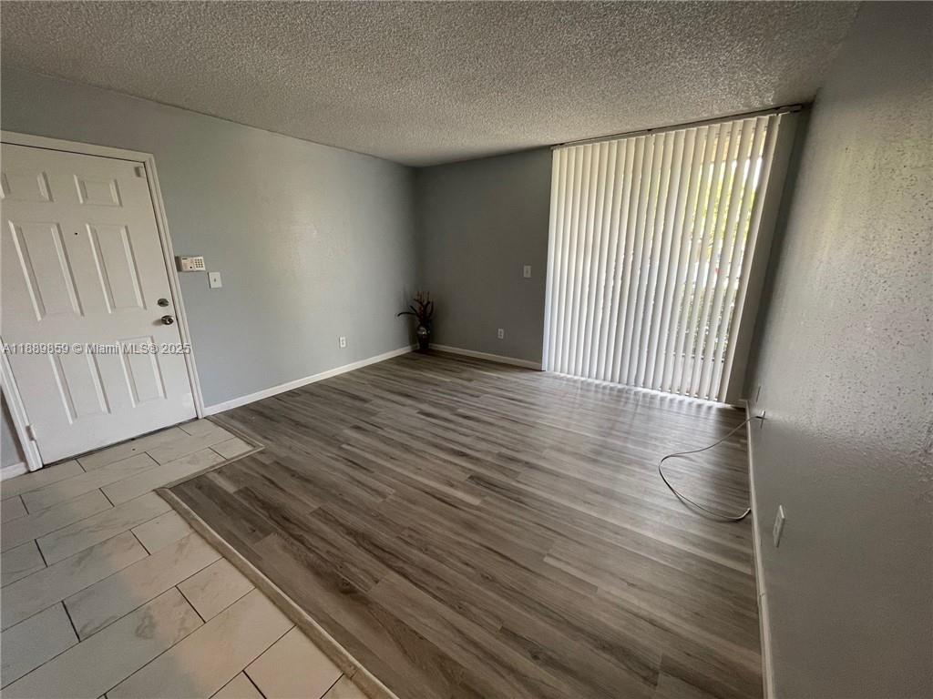 3985 West McNab Road, Unit A101 Pompano Beach, FL 33069 - Photo 3 of 13 a view of a room with wooden floor and windows