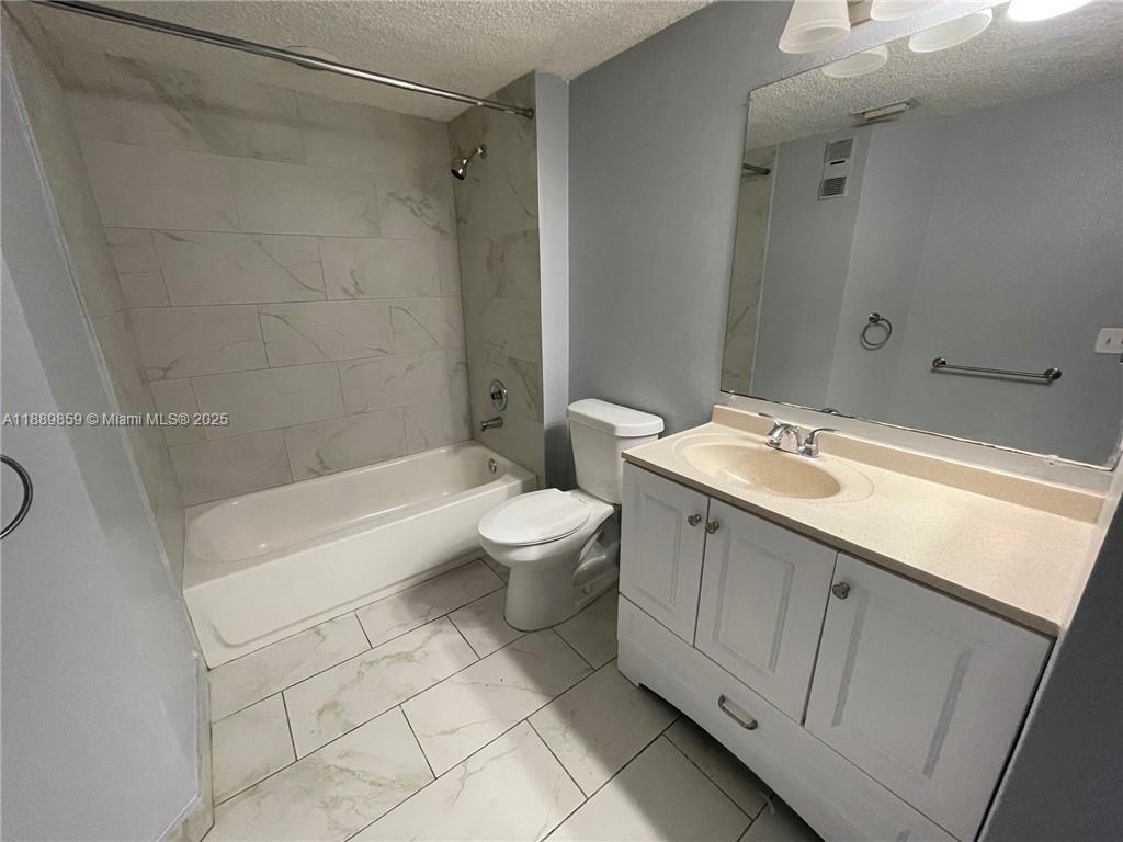 3985 West McNab Road, Unit A101 Pompano Beach, FL 33069 - Photo 6 of 13 a bathroom with a double vanity sink toilet and shower