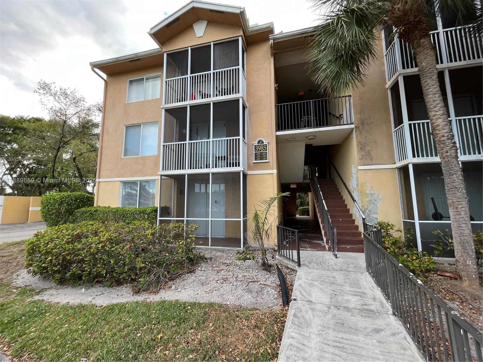 3985 West McNab Road, Unit A101 Pompano Beach, FL 33069 - Photo 10 of 13 a front view of a house with a yard