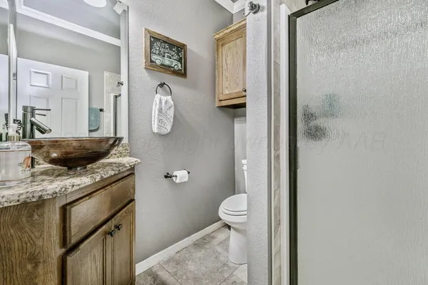 a bathroom with a granite countertop sink a toilet and a mirror