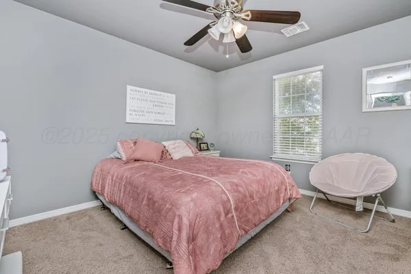 a bedroom with a bed chandelier and a window