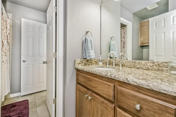 a bathroom with a granite countertop sink and a mirror