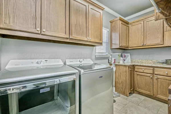 a utility room with stainless steel appliances granite countertop a sink and a stove