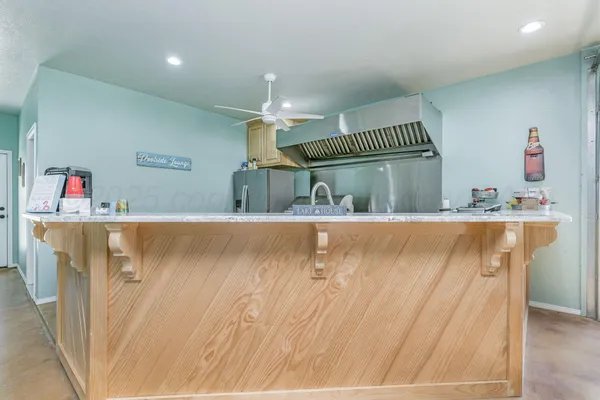 a kitchen with granite countertop a sink stainless steel appliances and counter space