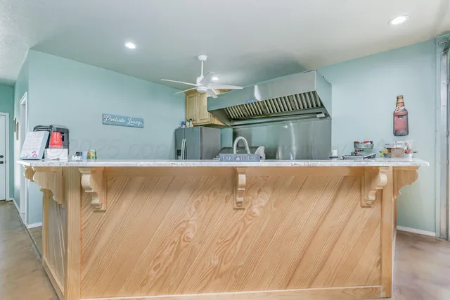 a kitchen with granite countertop a sink stainless steel appliances and counter space