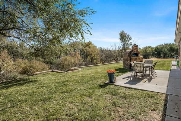a view of a house with a big yard and large trees