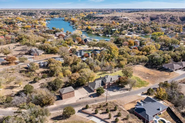 an aerial view of house with yard and lake view