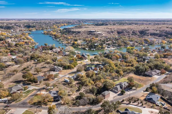 an aerial view of a house with a yard and lake view