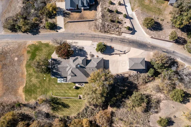 a view of a house with pool plants and large trees