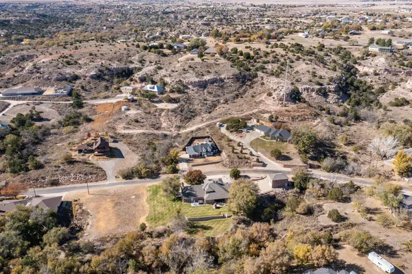 an aerial view of residential house with pool and trees all around
