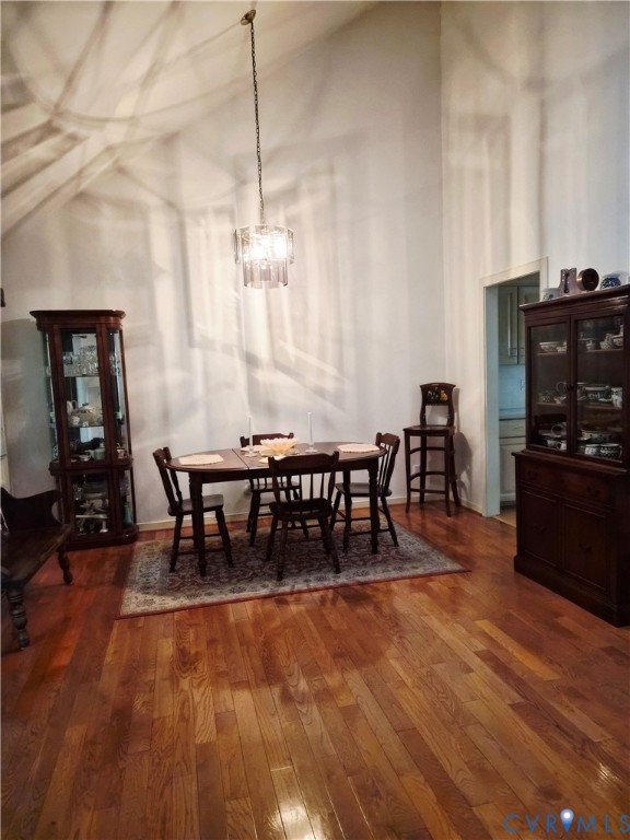 4099 Doe Run Road Hopewell, VA 23860 - Photo 15 of 35 a dining room with furniture wooden floor a rug a flat screen tv a painting and a chandelier