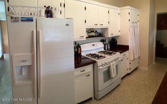 700 Espanola Way Melbourne, FL 32901 - Photo 3 of 15 a kitchen with stainless steel appliances a refrigerator a stove and white cabinets