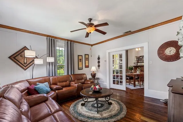 a living room with furniture a wooden floor and a chandelier