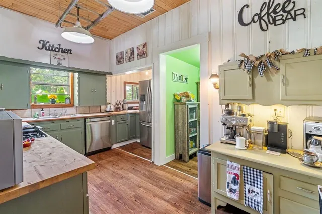 a kitchen with a sink dishwasher a stove and a refrigerator with wooden floor