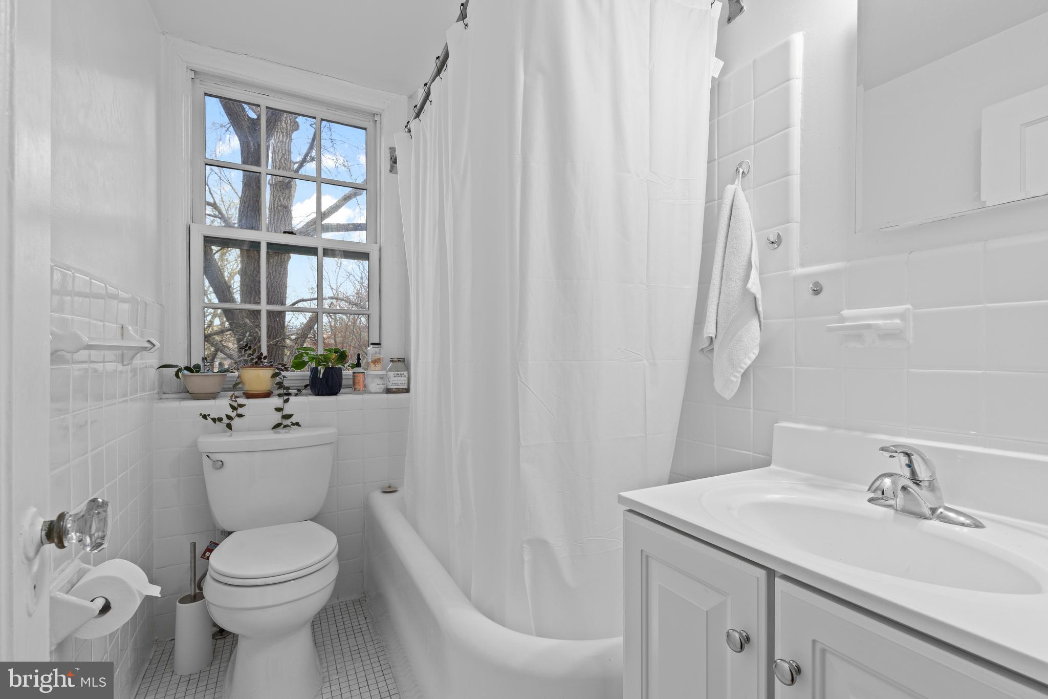2032 Belmont Road Northwest, Unit 204 Washington, DC 20009 - Photo 12 of 25 a bathroom with a sink a toilet and a mirror