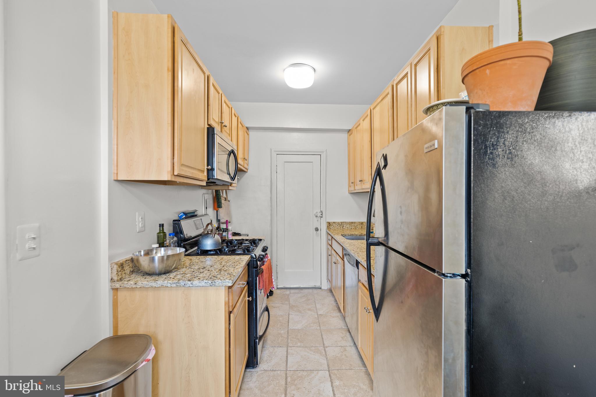 2032 Belmont Road Northwest, Unit 204 Washington, DC 20009 - Photo 14 of 25 a kitchen with a refrigerator and a sink
