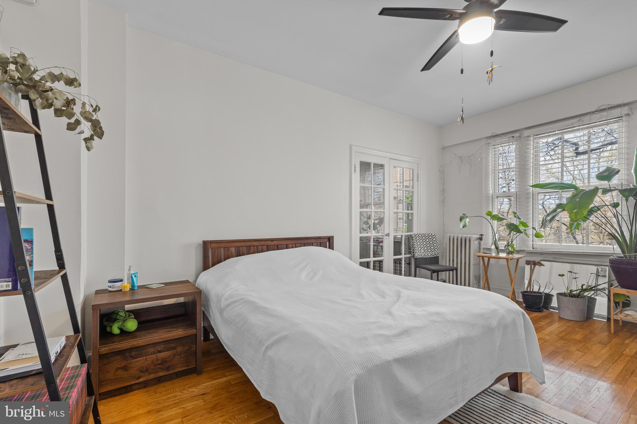 2032 Belmont Road Northwest, Unit 204 Washington, DC 20009 - Photo 6 of 25 a bedroom with a bed a chandelier and a flat tv screen