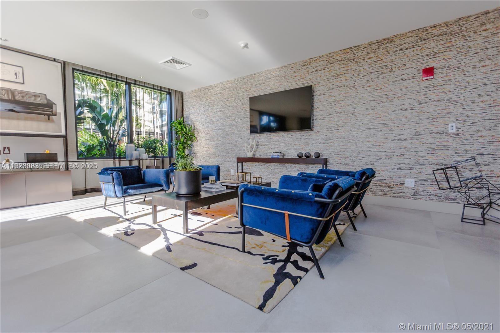 121 Northeast 34th Street, Unit 1604 Miami, FL 33137 - Photo 44 of 53 a living room with furniture a flat screen tv and a floor to ceiling window