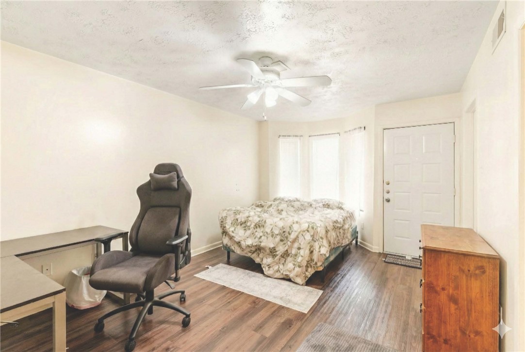 4441 Old College Road, Unit 2104 Bryan, TX 77801 - Photo 11 of 15 a bedroom with a bed and chair