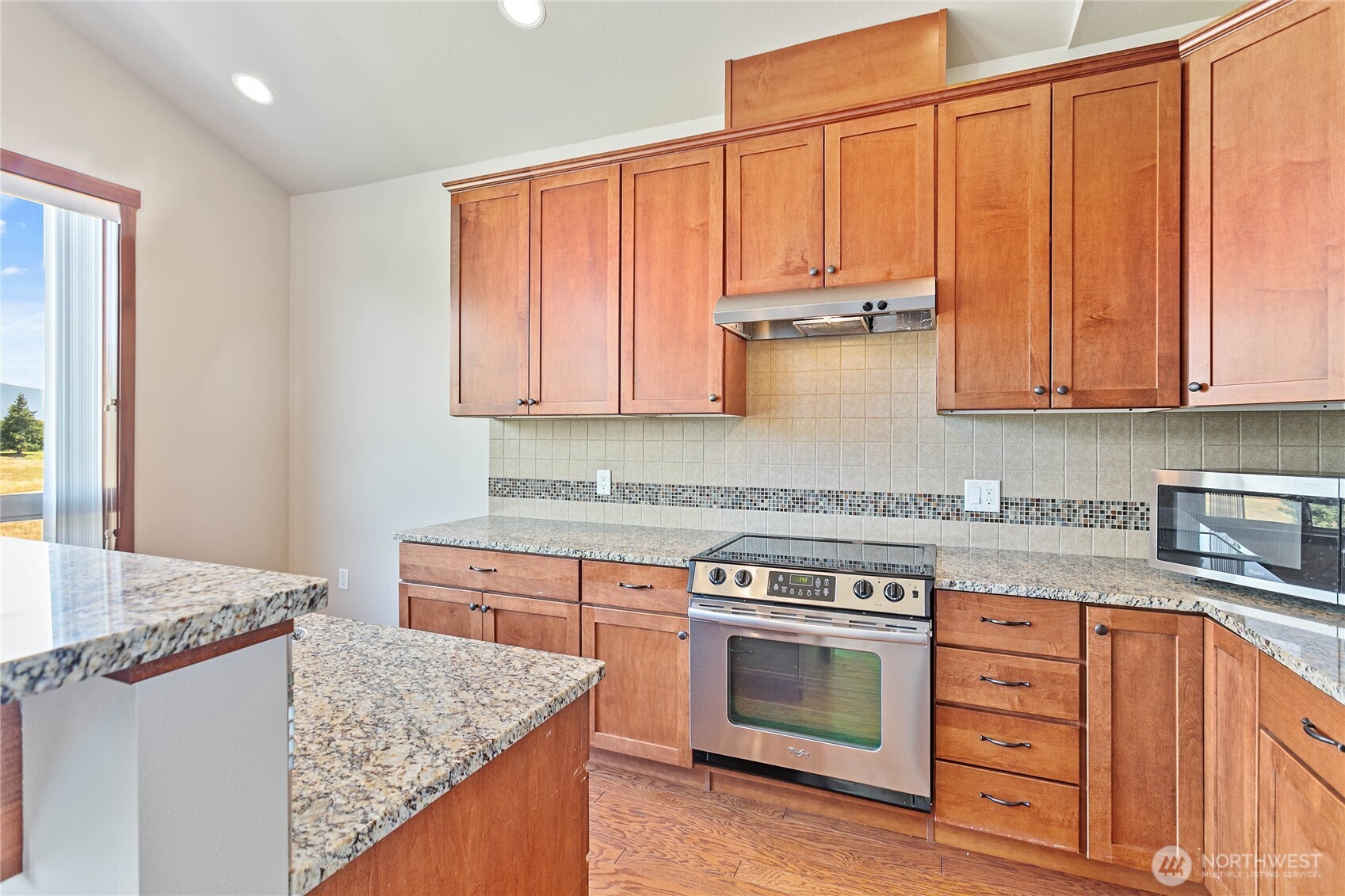 8780 Depot Road, Unit 308 Lynden, WA 98264 - Photo 9 of 36 a kitchen with stainless steel appliances granite countertop a stove a sink and a microwave