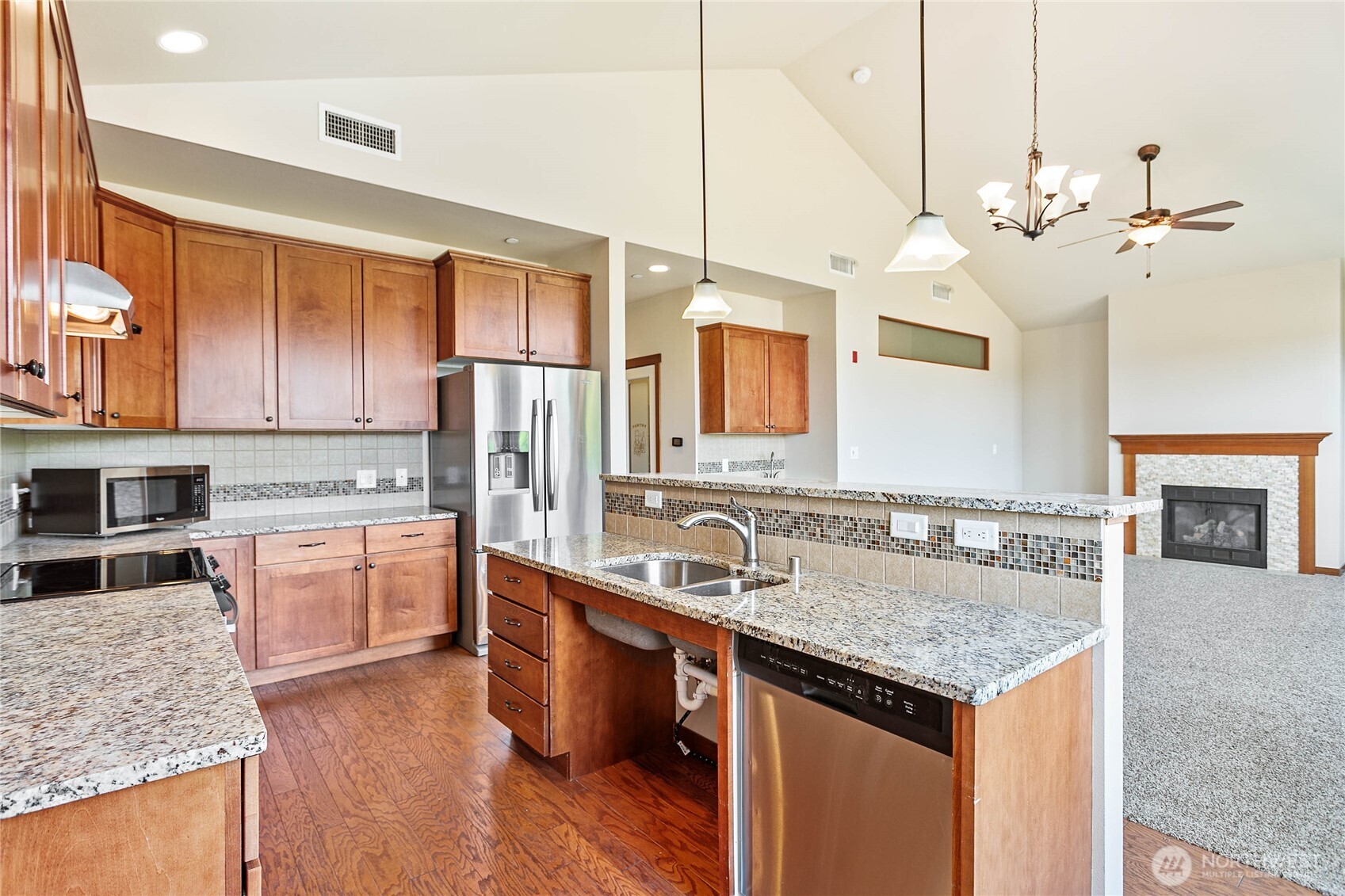 8780 Depot Road, Unit 308 Lynden, WA 98264 - Photo 10 of 36 a kitchen with a stove center island cabinets and wooden floor