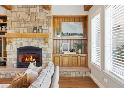 a living room with furniture a fireplace and a large window