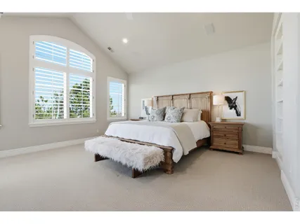 a spacious bedroom with a bed a couch and a window