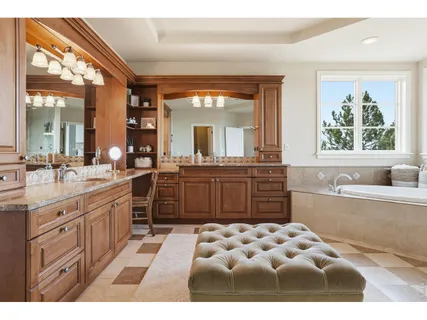 a large bathroom with a double vanity sink a mirror a bathtub and next to a window