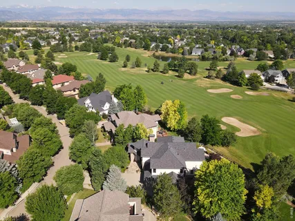 an aerial view of residential houses with outdoor space and trees