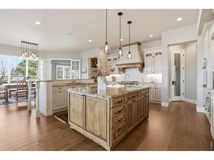 a kitchen with stainless steel appliances granite countertop a stove and a view of living room