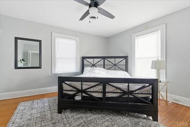 a bedroom with a bed window and wooden floor