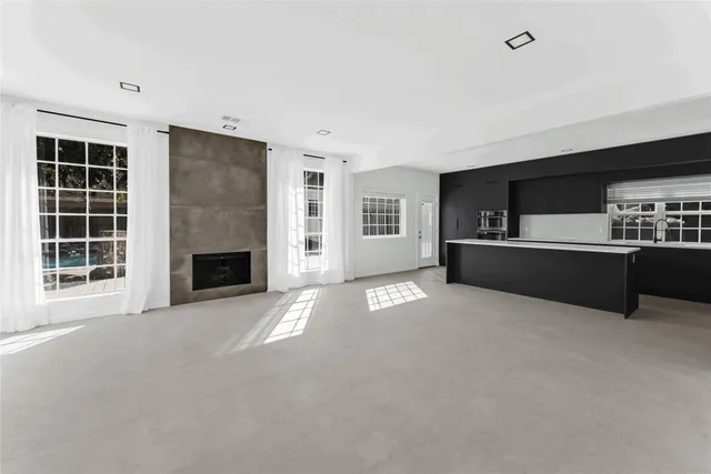 a view of an empty room with a fireplace and a window