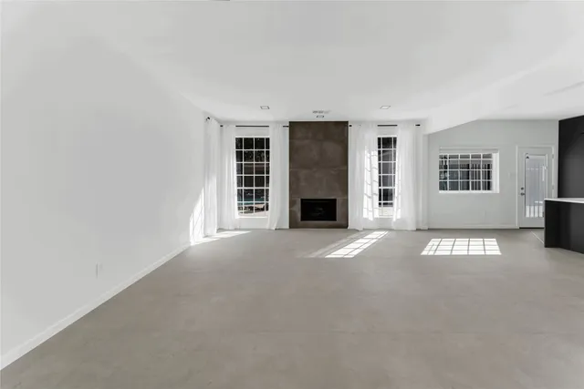 a spacious bedroom with a bed and a large window