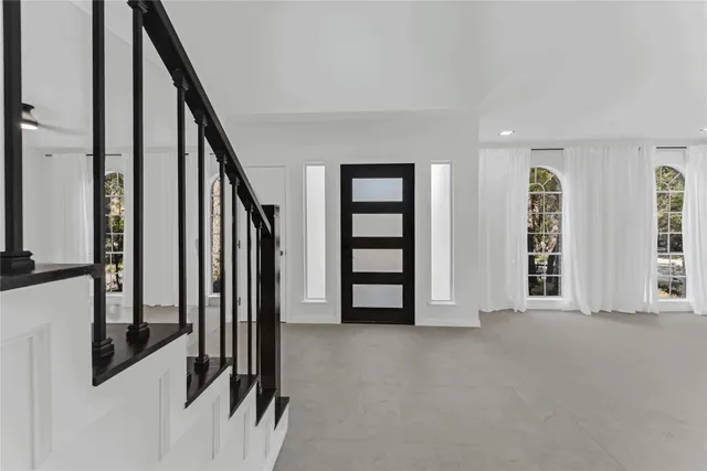 an entryway with a white walls and stairs